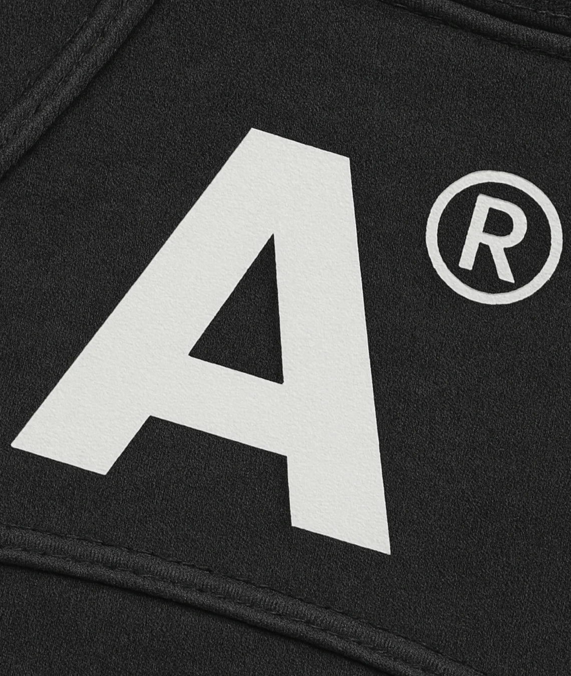 Black fabric with a large white letter 'A' and a registered trademark symbol.