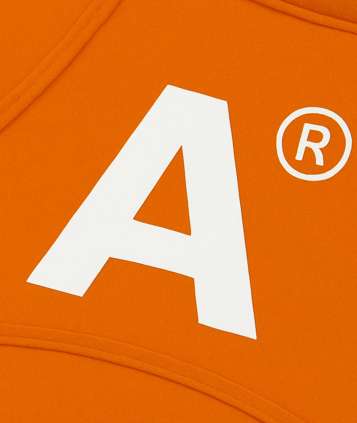 Close-up of an orange fabric with a white letter 'A' and registered trademark symbol.