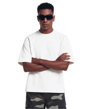 Man wearing a white t-shirt and camouflage pants with sunglasses on a white background