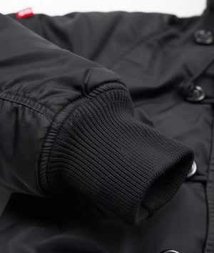Close-up of a black jacket with knit cuffs and buttons.