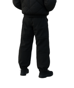 Person wearing a black puffer jacket and pants on a white background