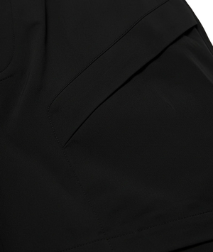 Close-up of black pants with a pocket detail