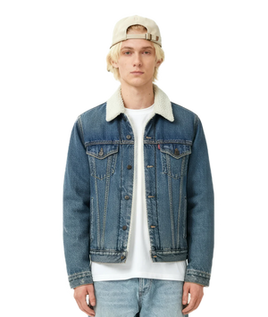 Person wearing a blue denim jacket with a white shirt underneath on a white background