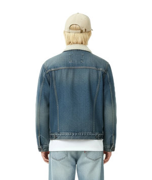 Person wearing a blue denim jacket and light-colored cap on a white background