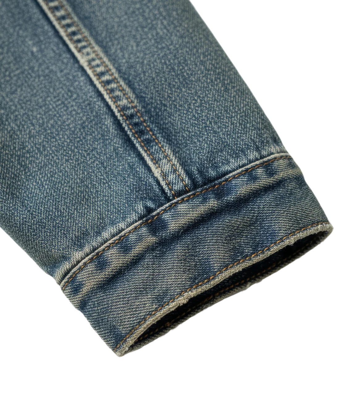 Close-up of rolled-up blue denim jeans on a white background