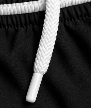 Close-up of black shorts with white shoelaces on a black background