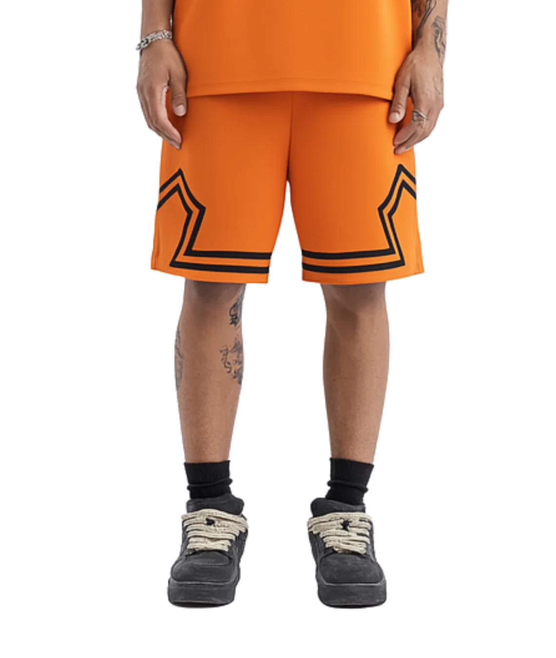 Person wearing orange shorts with black star designs on a white background