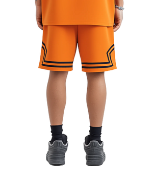 Person wearing orange shorts with black accents on a white background