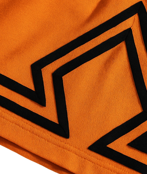Close-up of orange fabric with black geometric patterns