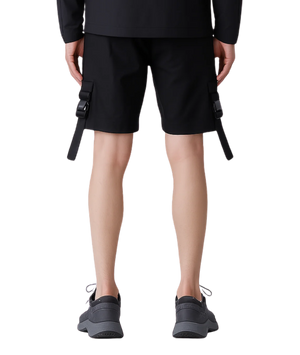 Person wearing black cargo shorts with a plain background