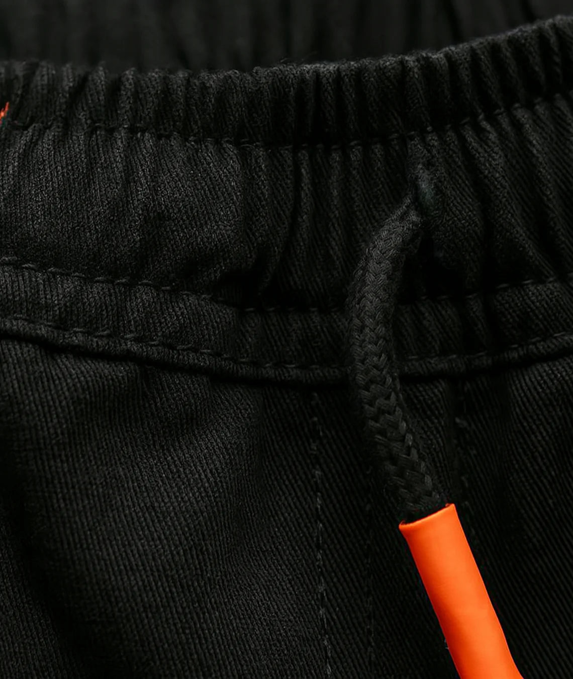 Close-up of black pants with an orange drawstring.