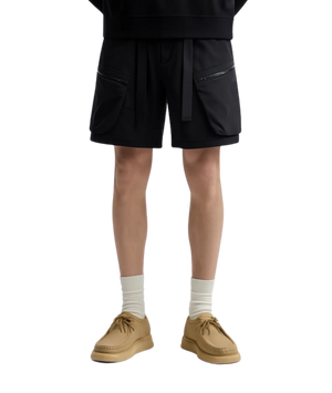 Person wearing a black outfit with beige shoes on a transparent background