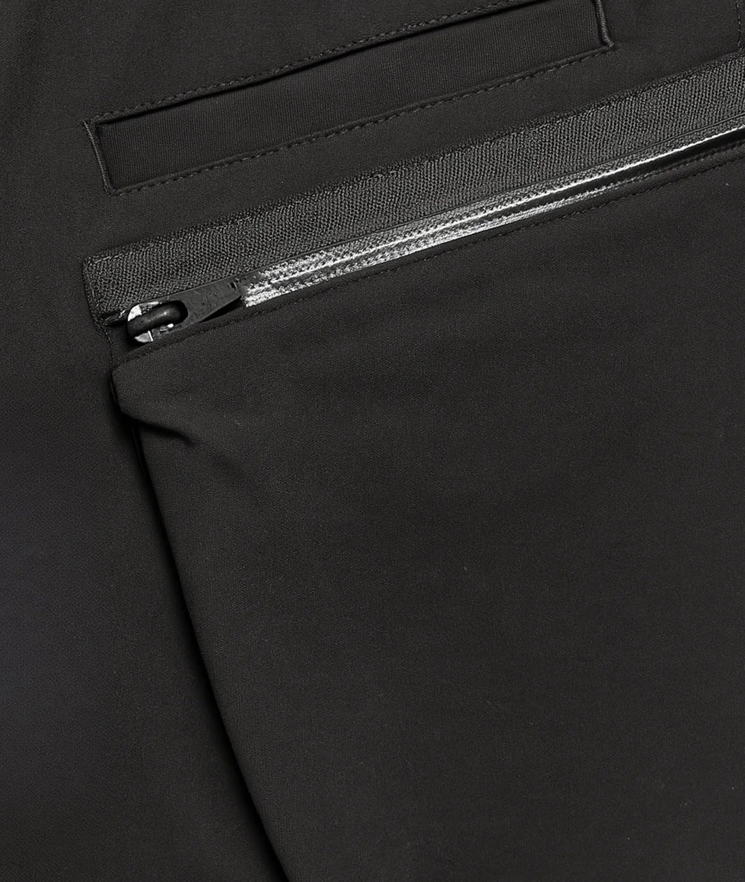 Close-up of a black zipper on a black fabric background