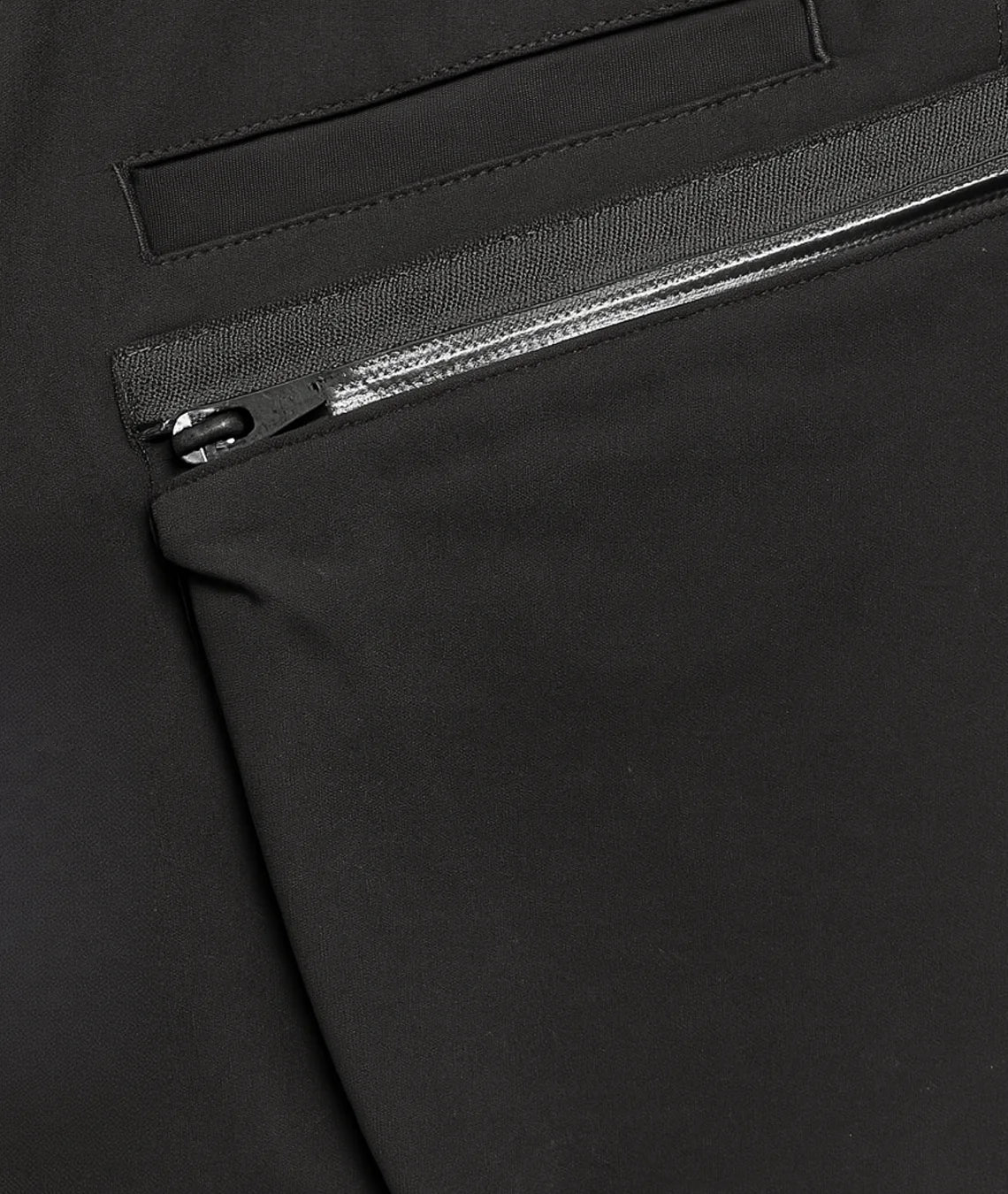 Close-up of a black zipper on a black fabric background