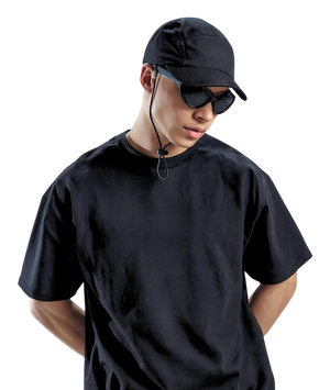Person wearing a black t-shirt, cap, and sunglasses on a white background