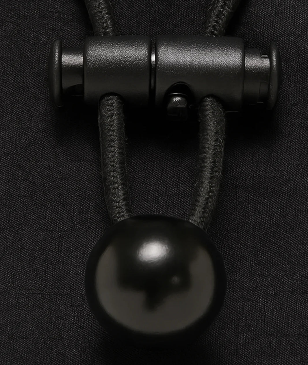 Close-up of a black metal clasp on dark fabric