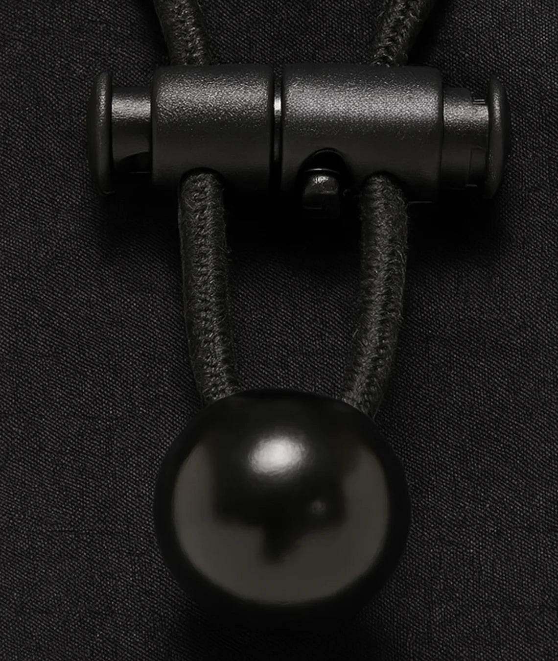 Close-up of a black metal clasp on dark fabric
