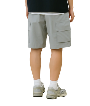 Person wearing light gray cargo shorts on a white background