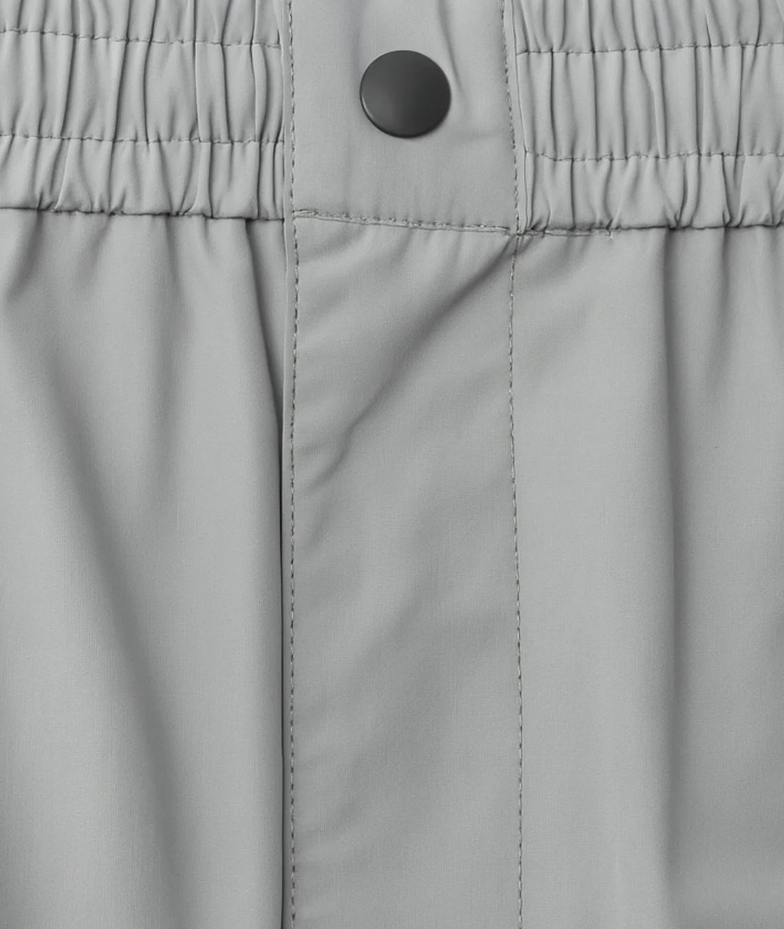 Close-up of gray pants with a button on the waistband