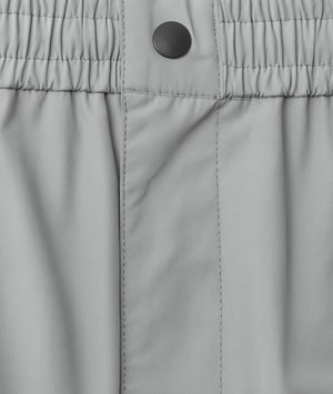 Close-up of gray pants with a button on the waistband