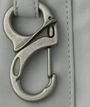 Metal carabiner attached to a gray fabric surface