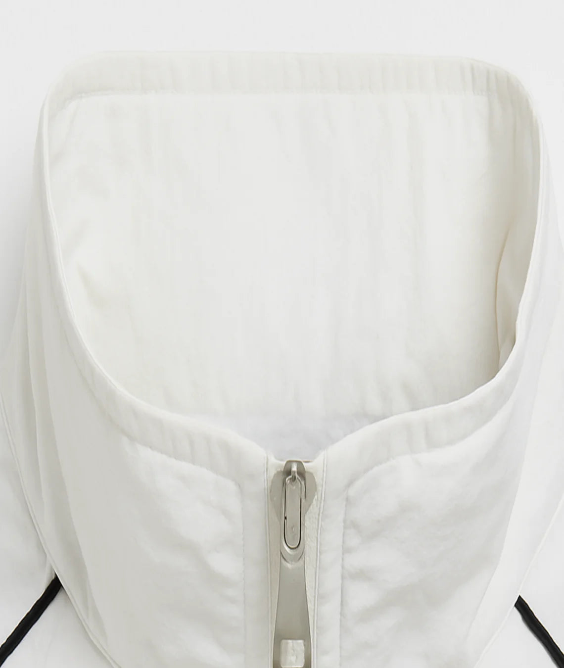 Close-up of a white jacket with a zipper on a light gray background