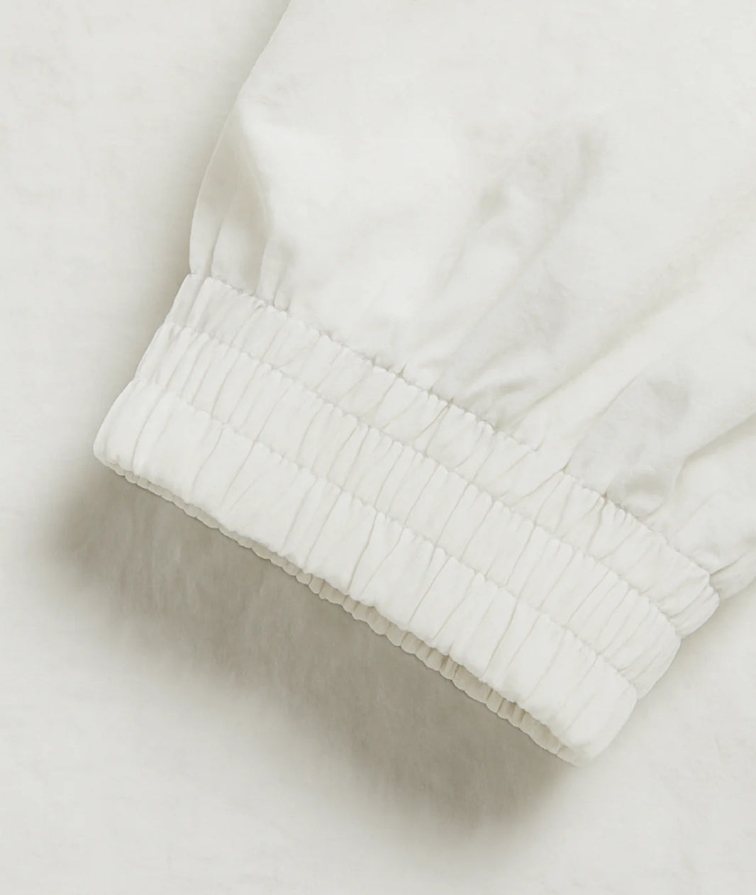 Close-up of a white textured fabric edge on a light background