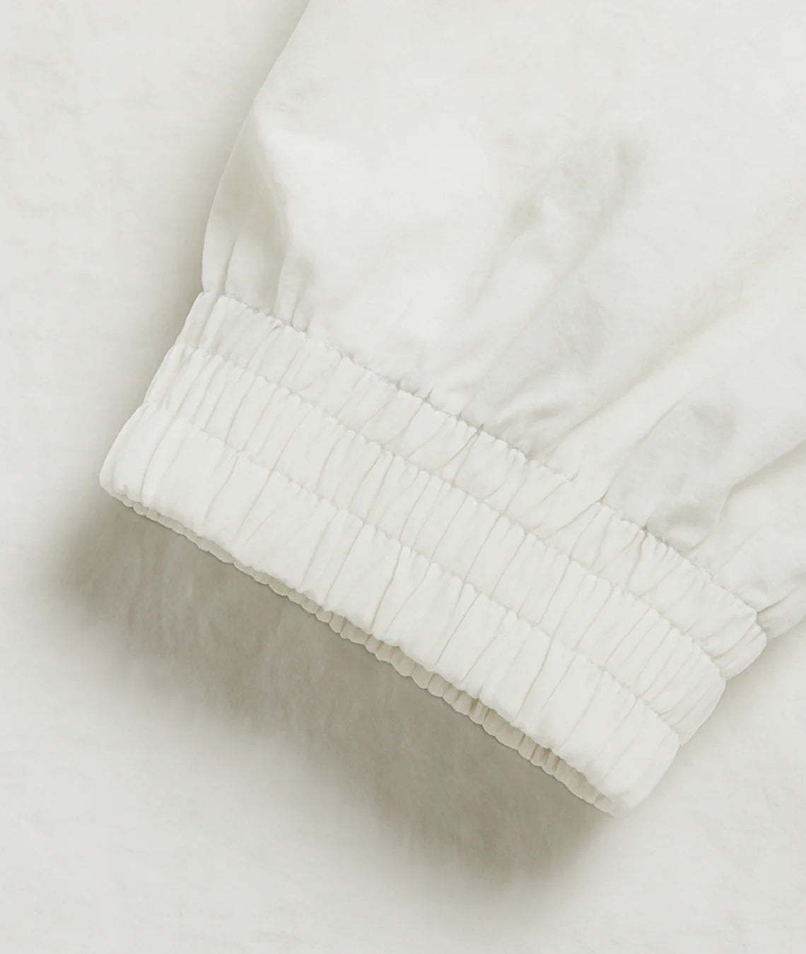 Close-up of a white textured fabric edge on a light background