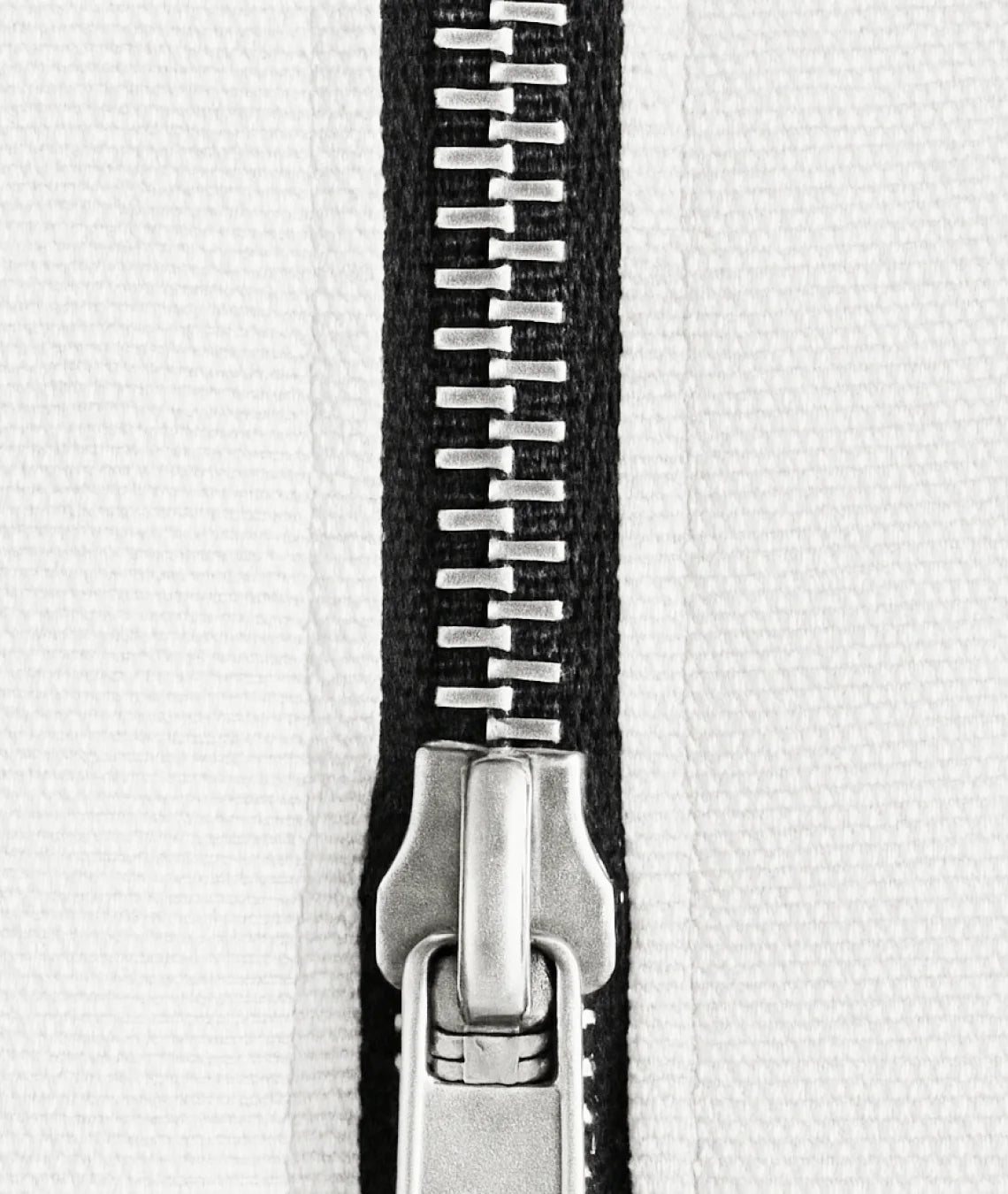 Close-up of a metal zipper on a white background