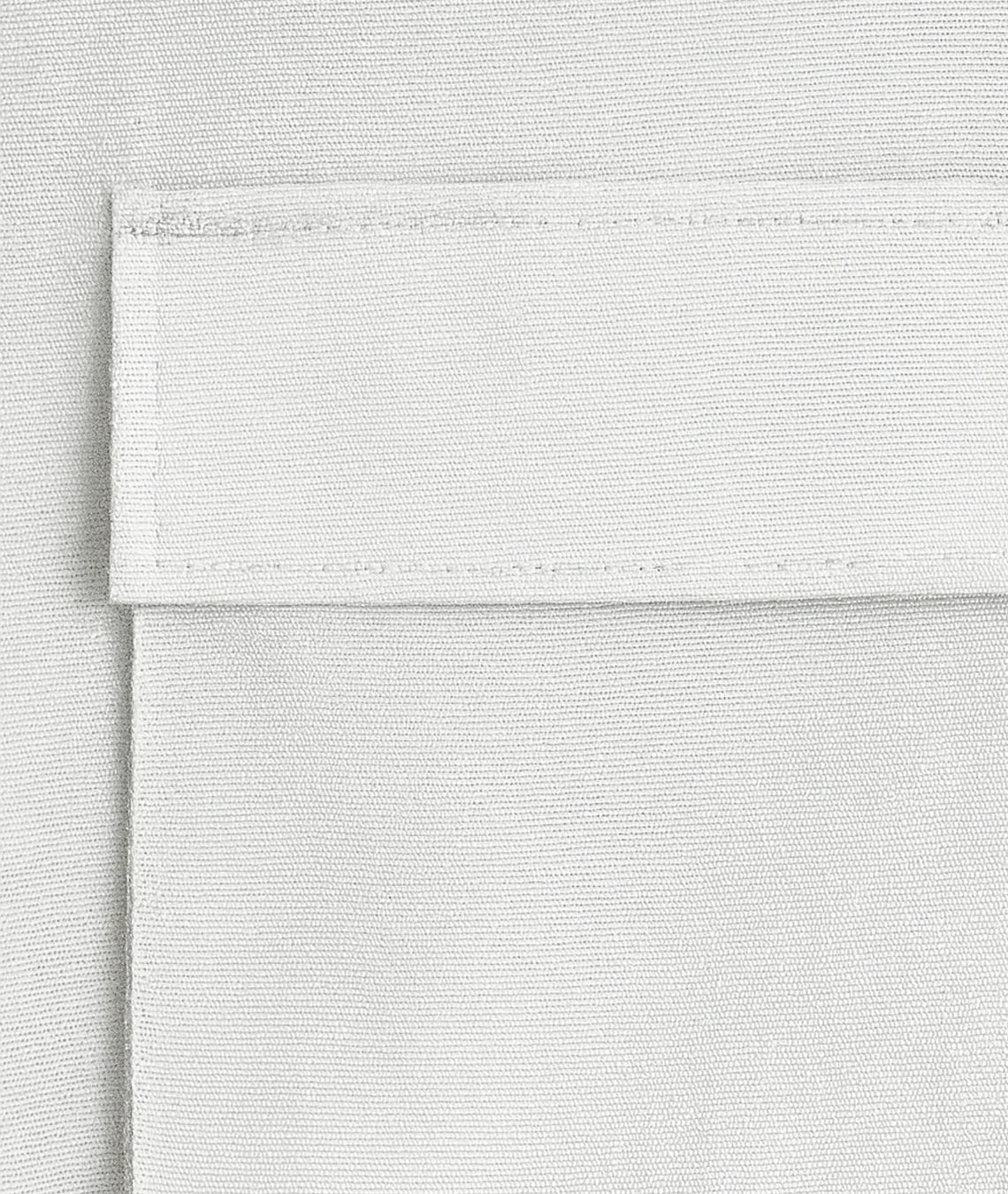 Close-up of a textured white fabric with a visible seam.
