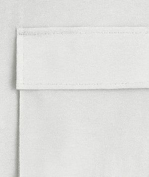 Close-up of a textured white fabric with a visible seam.