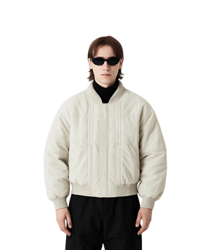 Person wearing a beige jacket and sunglasses on a white background