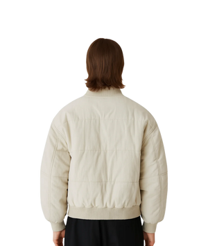 Person wearing a beige bomber jacket from behind on a white background