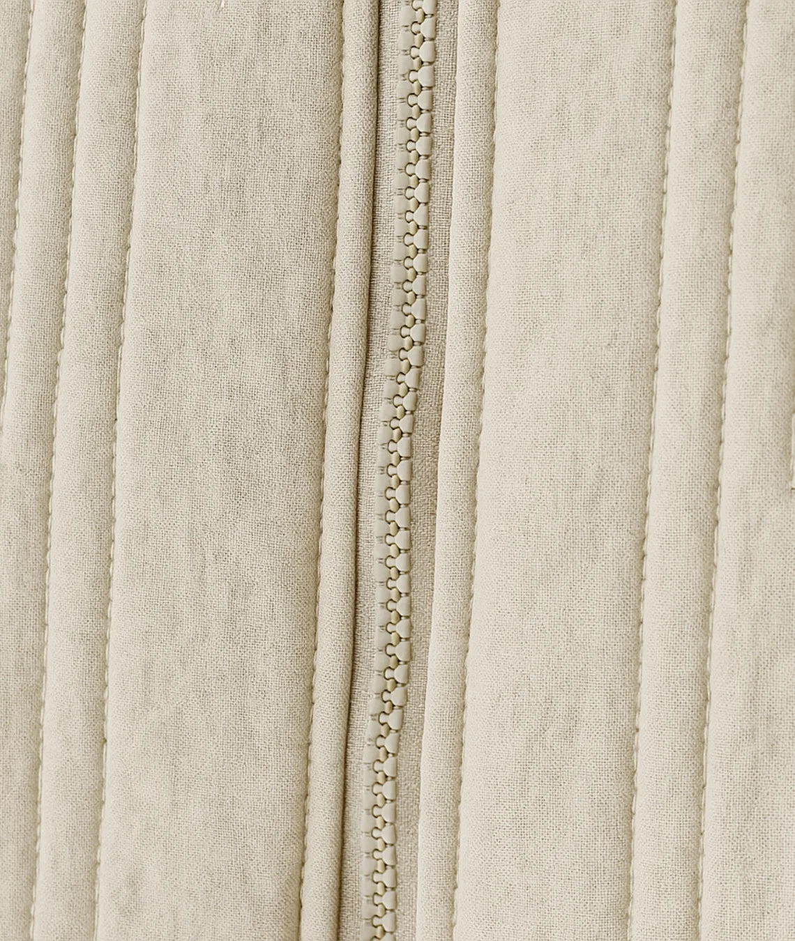 Close-up of a beige fabric with a zipper running vertically.