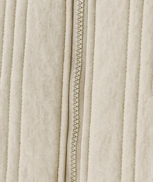 Close-up of a beige fabric with a zipper running vertically.